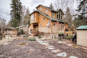 Ein zweistöckiges Holzhaus mit einem Steinweg, der zur Haustür führt.