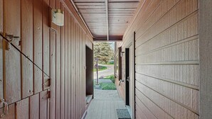 A covered hallway with wooden walls and a metal roof, leading to a garage door. - Convenient Studio, Walking Distance to Sun Valley Lake - Shopping, Skiing Nearby (Sun Valley)