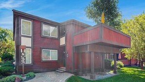 A modern two-story building with a red exterior, a covered porch, and a landscaped front yard. - Convenient Studio, Walking Distance to Sun Valley Lake - Shopping, Skiing Nearby (Sun Valley)