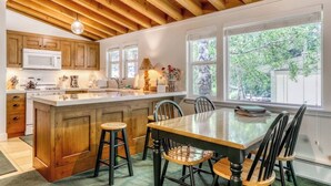 Una cocina con armarios de madera, un microondas blanco y una isla grande con taburetes.
