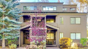 Un edificio moderno su due piani con un portico, ampie finestre e un giardino curato.