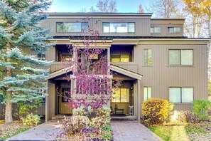 A modern two-story building with a front porch, large windows, and a well-maintained garden. - Charming condo with mountain views, fireplace, hot tub & deck (Ketchum)