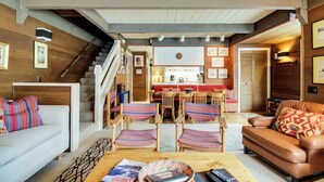 A spacious living area with a staircase, a dining table with chairs, and a cozy seating area with a sofa and a coffee table. - Cozy Condo w/ Free WiFi, Heated Pool & Tennis - Close to Skiing (Sun Valley)