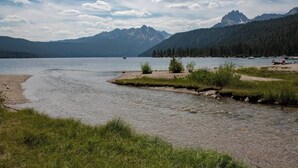 A river with a mountainous backdrop, a clear sky, and a small dock.