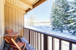 A wooden deck with a table and chairs, overlooking a snowy landscape with trees. - Cozy Mountain Abode with WiFi, Pool, & Perfect Location Near Downtown Ketchum (Sun Valley)