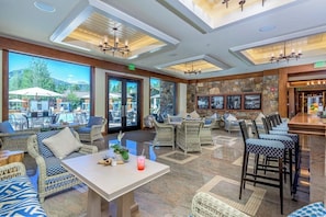 A spacious indoor area with wicker furniture, a bar, and large windows offering views of outdoor seating. - Close to Sun Valley Resort w/ access pass to resort amenities (Sun Valley)