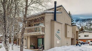 Een houten gebouw met een balkon, een schoorsteen en een bordje met sauna.