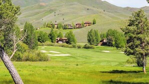 En golfbana med ett klubbhus och flera byggnader som ligger på en sluttning.
