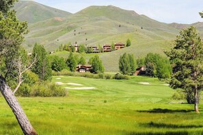 Ein Golfplatz mit Klubhaus und mehreren Gebäuden an einem Hang.