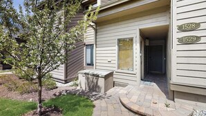 A modern building with two visible door numbers, 1528 and 1529, and a small tree in the front yard. - Rustic home with gas fireplace, pool & hot tub - ski-in/out to Dollar Mountain (Sun Valley)