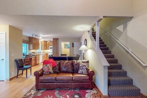 Ein Wohnzimmer mit einer Ledersofa, einem Essbereich und einer Treppe.