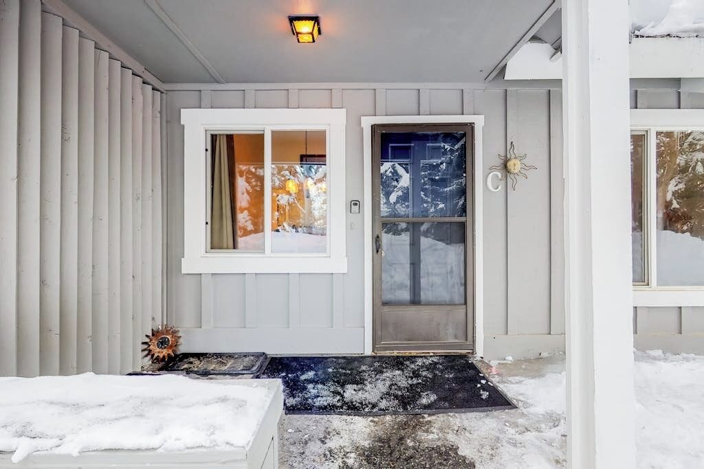 A house with a front door, a window, and a light fixture.
