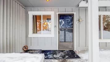 A house with a front door, a window, and a light fixture.