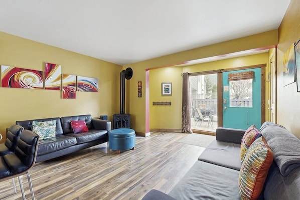 Ein Wohnzimmer mit Sofa, Hocker und Kamin.