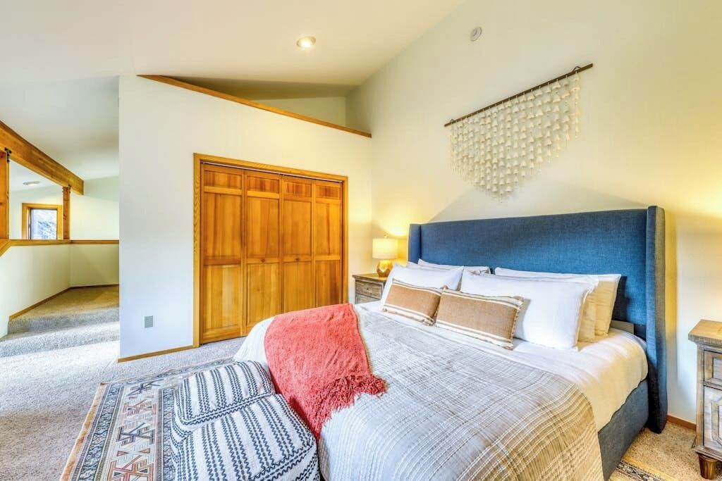 Ein Schlafzimmer mit Bett, Holzschrank und einer Kronleuchter.