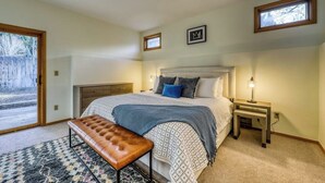 A bedroom with a bed, bench, bedside table, and a window. - Newly-updated Warm Springs condo w/ski & mountain views - Dogs ok (Ketchum)