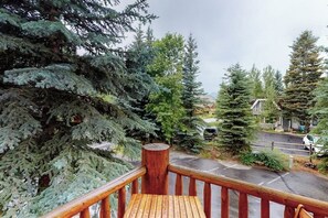 A wooden deck with a view of a road and houses. - Comfortable, centrally-located condo close to skiing, hiking, & downtown (Ketchum)