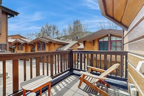 Eine Holzhütte mit einem Balkon, einem Holztisch und zwei Holzstühlen.