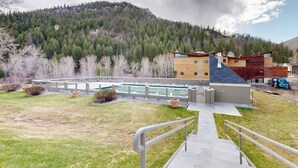 A modern building with a pool, surrounded by a mountain landscape. - Wonderful Mountain Getaway W/ Shared Pool, Multiple Balconies, Gas Grill & WiFi (Ketchum)
