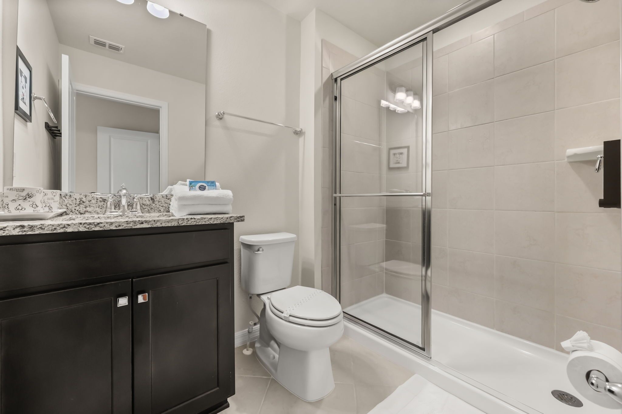 A modern bathroom with a shower, toilet, and vanity.