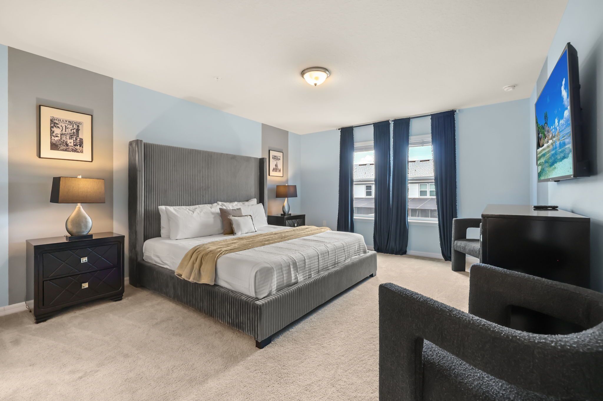 Una camera d'hotel con un letto grande, comodini, una TV e vista sulla città.