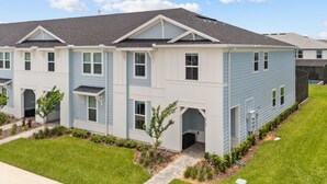 A multi-story residential building with a symmetrical facade, multiple windows, and a central entrance. - 5 BD/ 4.5 BA Windsor Cay (1276 BP) (Clermont)