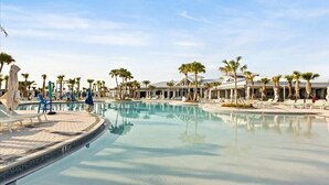 A large, clear swimming pool with lounge chairs and palm trees, surrounded by a resort-style building. - 5 BD/ 4.5 BA Windsor Cay (1276 BP) (Clermont)