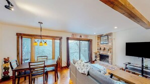 Una sala de estar acogedora con chimenea, muebles de madera y televisor.