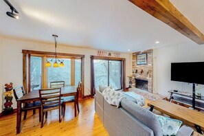 Ein gemütliches Wohnzimmer mit Kamin, Holzmöbeln und einem Fernseher.