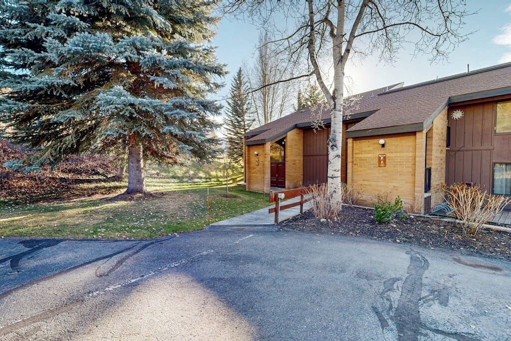 A lodge with a wooden exterior, a covered porch, and a paved driveway.