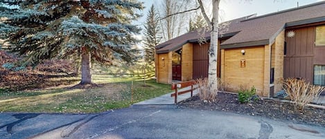 A lodge with a wooden exterior, a covered porch, and a paved driveway.