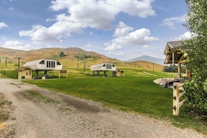 A rural setting with two white cabins, a gravel path, and a grassy field. - Bright Condo Less than a Mile to Ski Lifts, Pool, Tennis (Sun Valley)