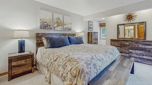 A bedroom with a bed, nightstands, a dresser, and wall art. - Lovely condo w/ beautiful views & shared pool/hot tub/tennis/golf (Sun Valley)