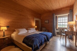 A wooden cabin room with a bed, two bedside tables, a desk, a chair, and a window with curtains. - 199 - Quinta dos Carvalhos (Castelo Branco)