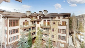 A multi-story building with balconies, a central courtyard, and a mountainous backdrop. - Modern mountain penthouse close to hikes & skiing (Sun Valley)
