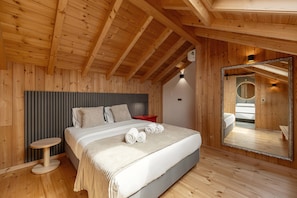 A wooden-paneled bedroom with a bed, bedside table, and a large mirror.