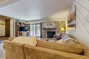 Ein Wohnzimmer mit Kamin, Fernseher und einer Couch.