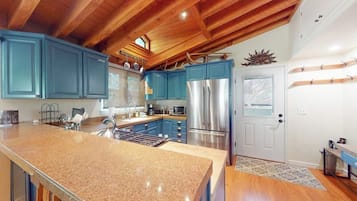 A kitchen with granite countertops, stainless steel appliances, and blue cabinets.