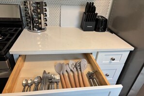 A kitchen with a drawer containing utensils, a spice rack, and a toaster. - Cozy ATL Stay Fast Wi-Fi + Close to Everything (Atlanta)