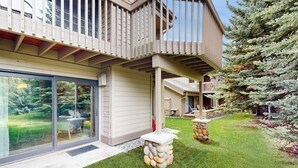 A modern house with a deck, a glass door entrance, and a stone pillar. - Gorgeous mountain retreat with pool, hot tub, games, & golf - walk-to-lifts (Sun Valley)