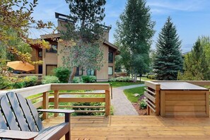 A modern building with a wooden deck, a bench, and a pathway leading to the entrance. - Charming condo with WiFi, deck, fireplace, shared pool, hot-tub, and sauna (Sun Valley)