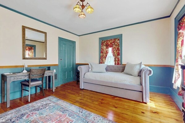 A room with a bed, a desk, a chair, a mirror, and a window with curtains. - Beautifully renovated home walk to boulevard, town & train (Gloucester)
