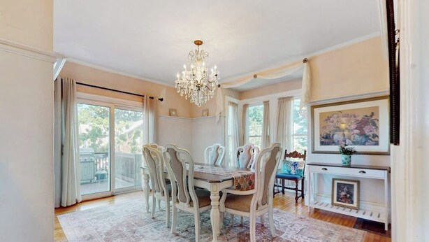 A dining room with a chandelier, a large window, and a fireplace. - Beautifully renovated home walk to boulevard, town & train (Gloucester)