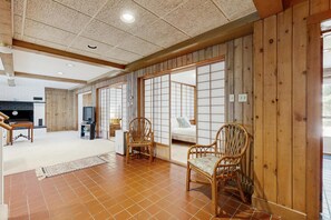 Una habitación tradicional japonesa con suelo de tatami, puertas correderas y un televisor.
