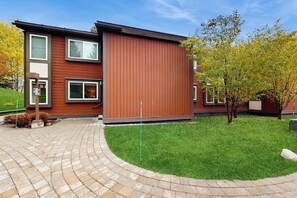 A modern two-story building with a brick driveway and a well-maintained lawn. - Cozy Sun Valley condo, walk to village, skiing and mountain adventures (Sun Valley)
