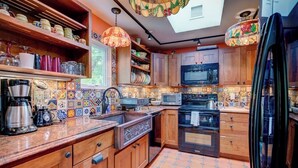 A kitchen with wooden cabinets, a microwave, a stove, and a refrigerator.