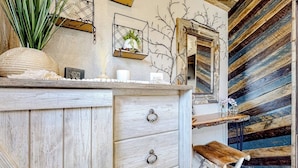 A rustic wooden interior with a wooden bench, a wall-mounted shelf with a plant, and a mirror. - Rustic getaway with fireplace, patio area, board games, full kitchen, & TV (Kalispell)