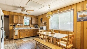 A wooden interior with a kitchen, dining table, and chairs.