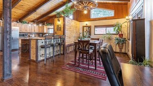 Una cocina amplia con armarios de madera, un comedor con alfombra roja y un ventanal grande.