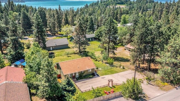 Un quartier résidentiel avec des maisons, une vue dégagée sur un lac et un paysage boisé.